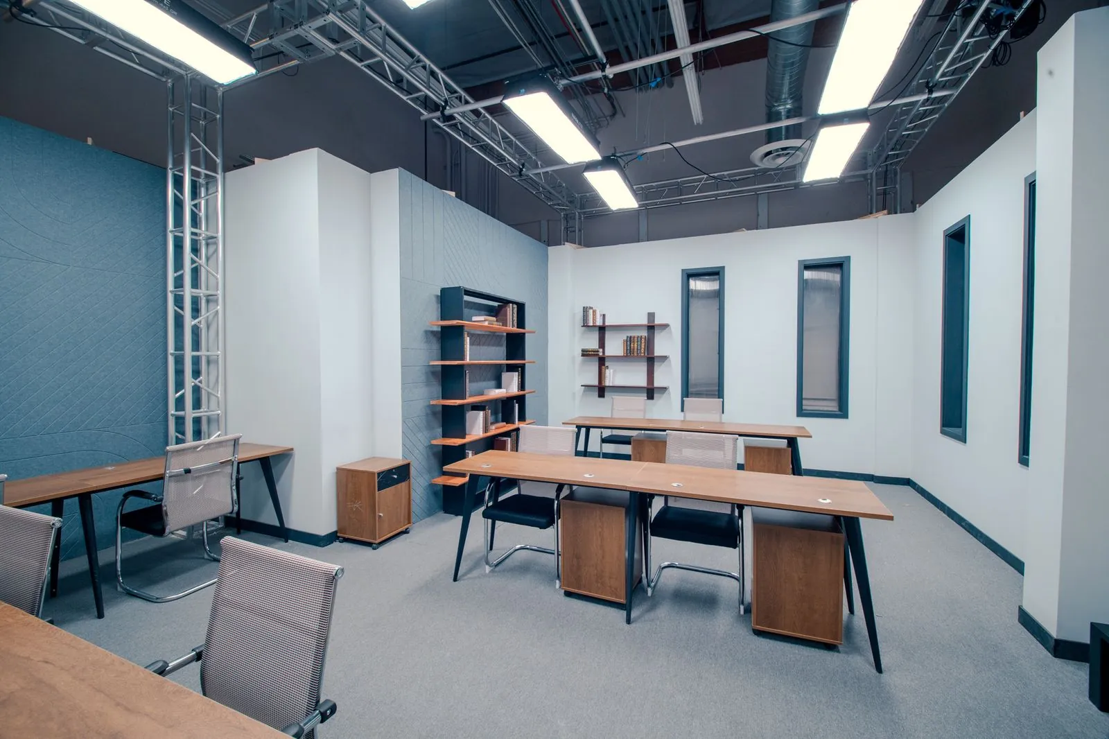 Open bullpen with desks, task chairs and an acoustic panel wall