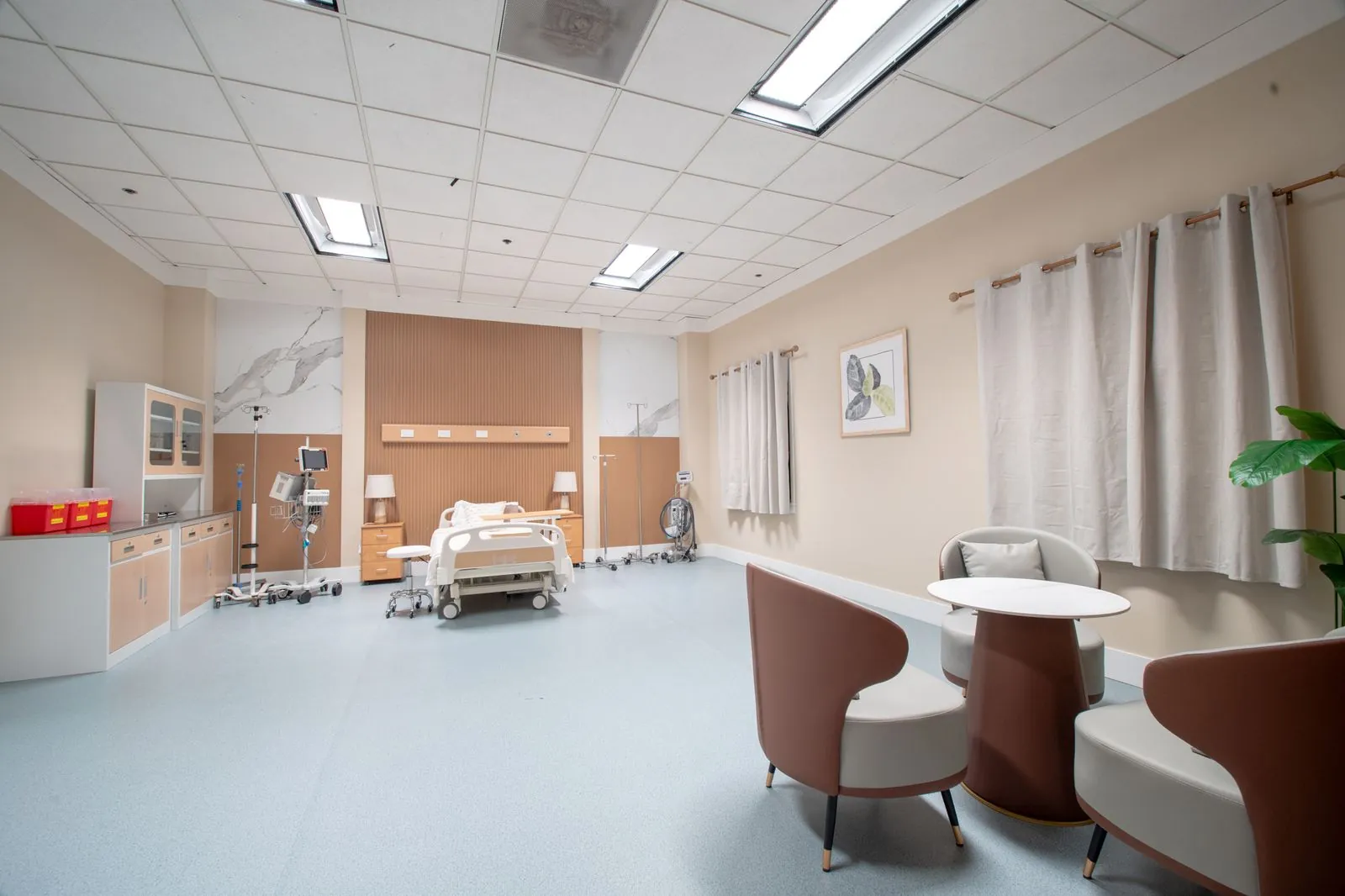 Private hospital room with bed, armchairs and a table