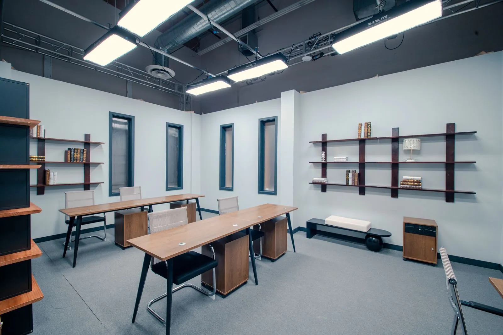 Bullpen workstations and shelving beside the office set's window wall
