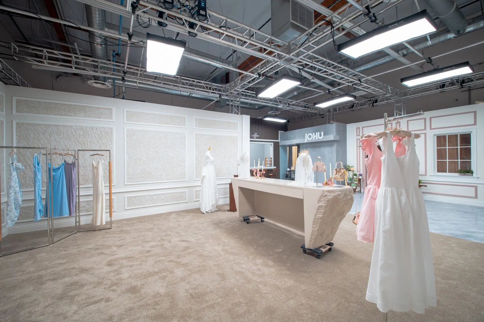 Dress rails and gowns along the bridal boutique wall