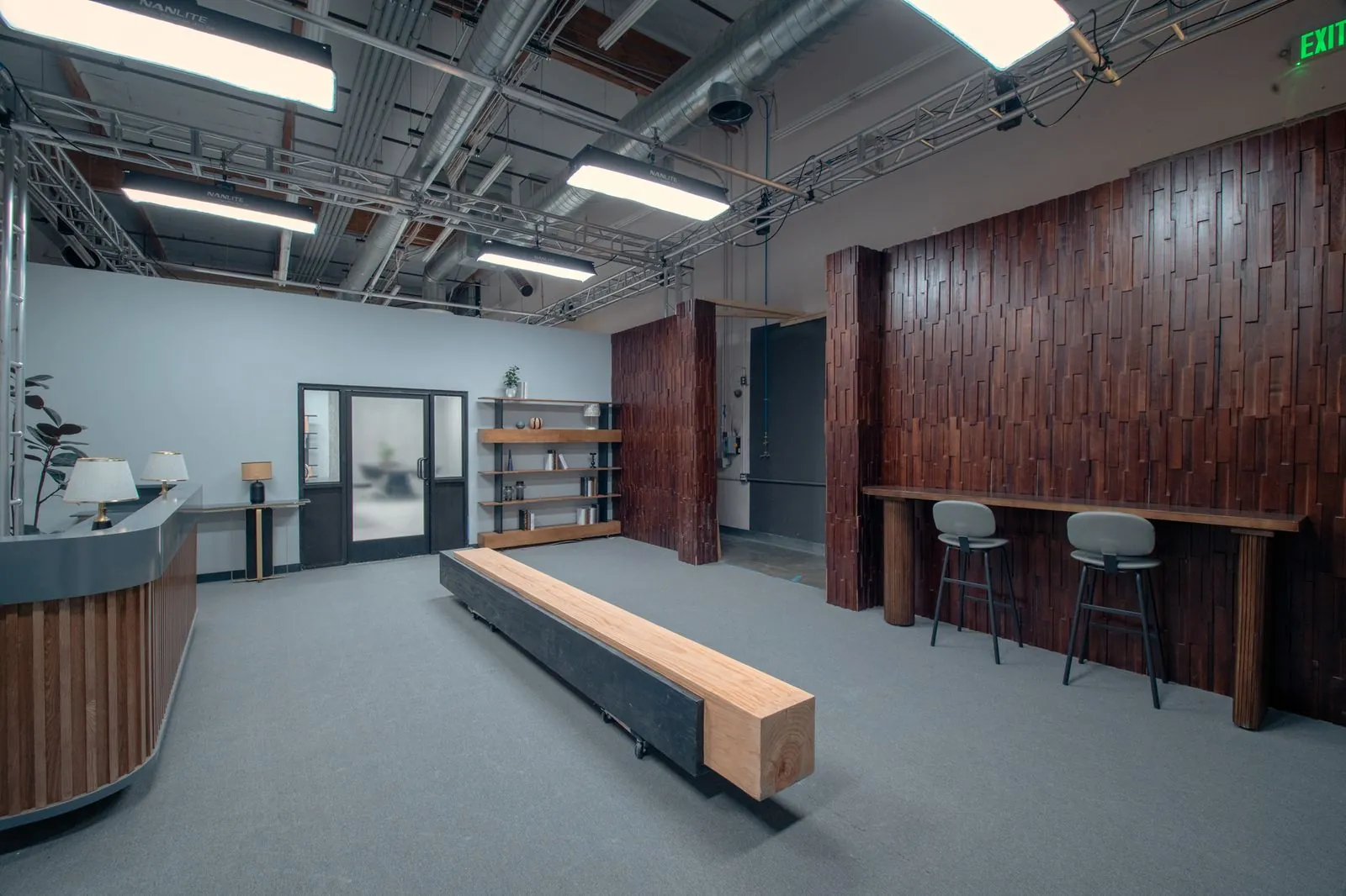 Standing counter and stools against the wood slat wall in the office lobby