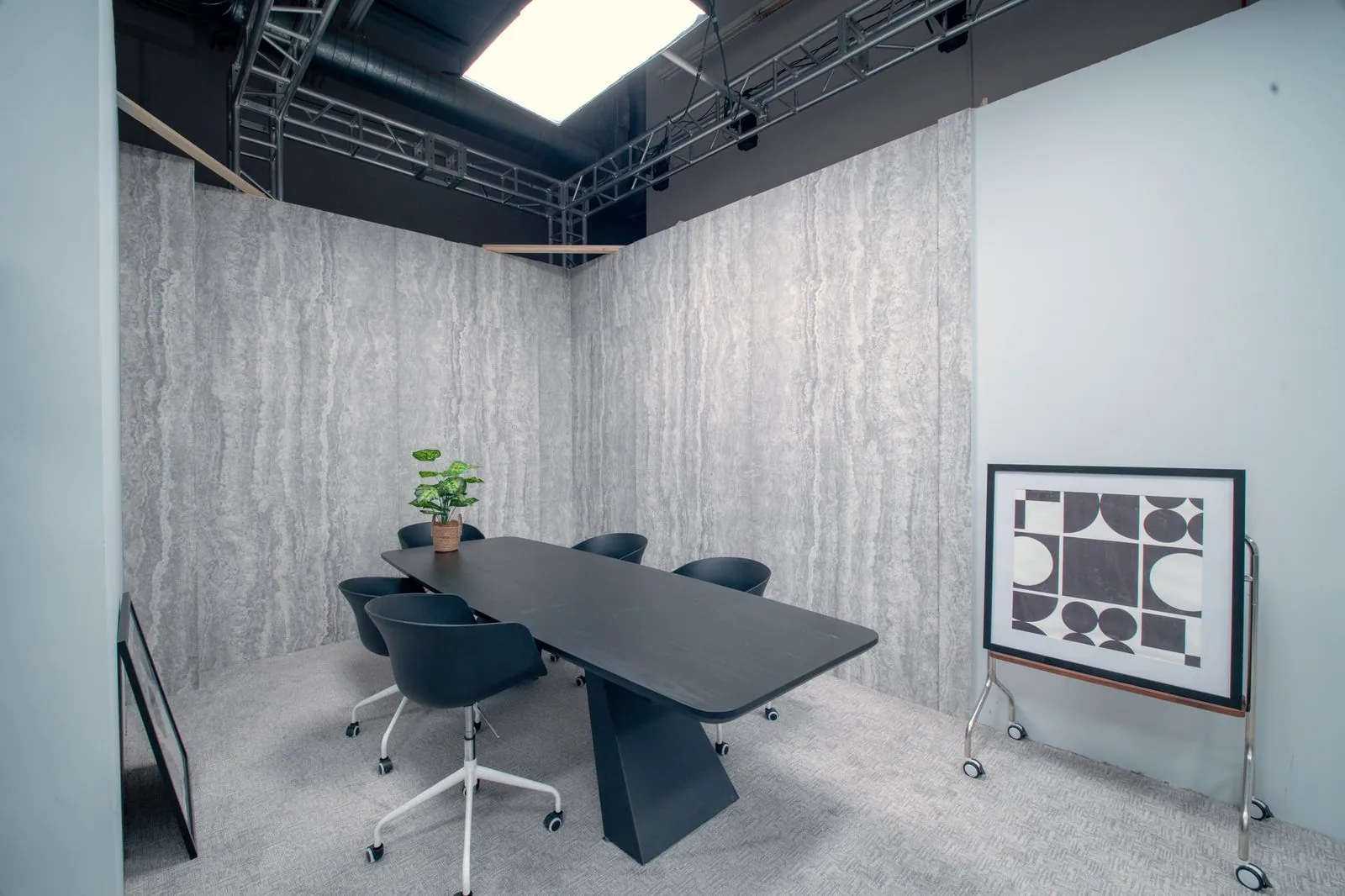 Conference room with a black table, six chairs and travertine walls
