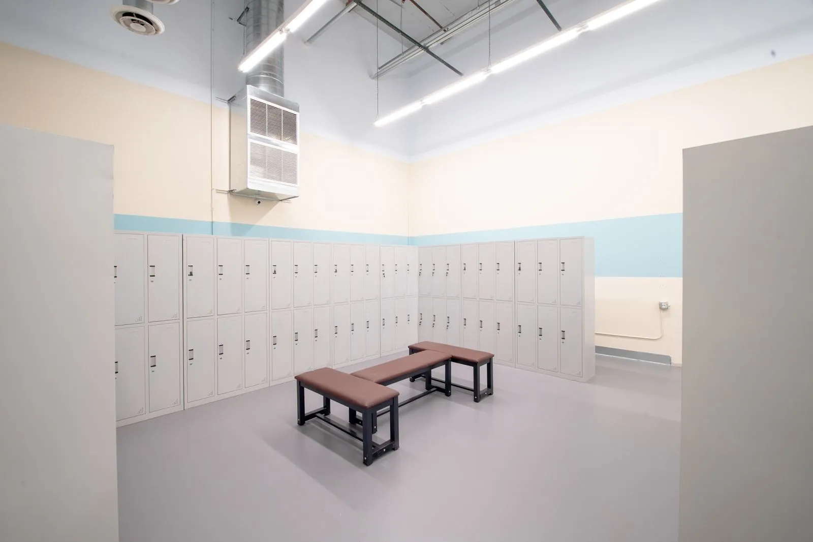 Locker room with benches and a full wall of lockers