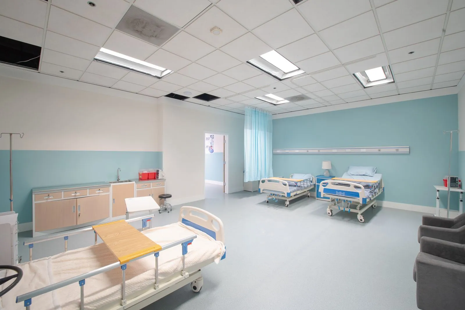 Hospital ward beds along the window wall
