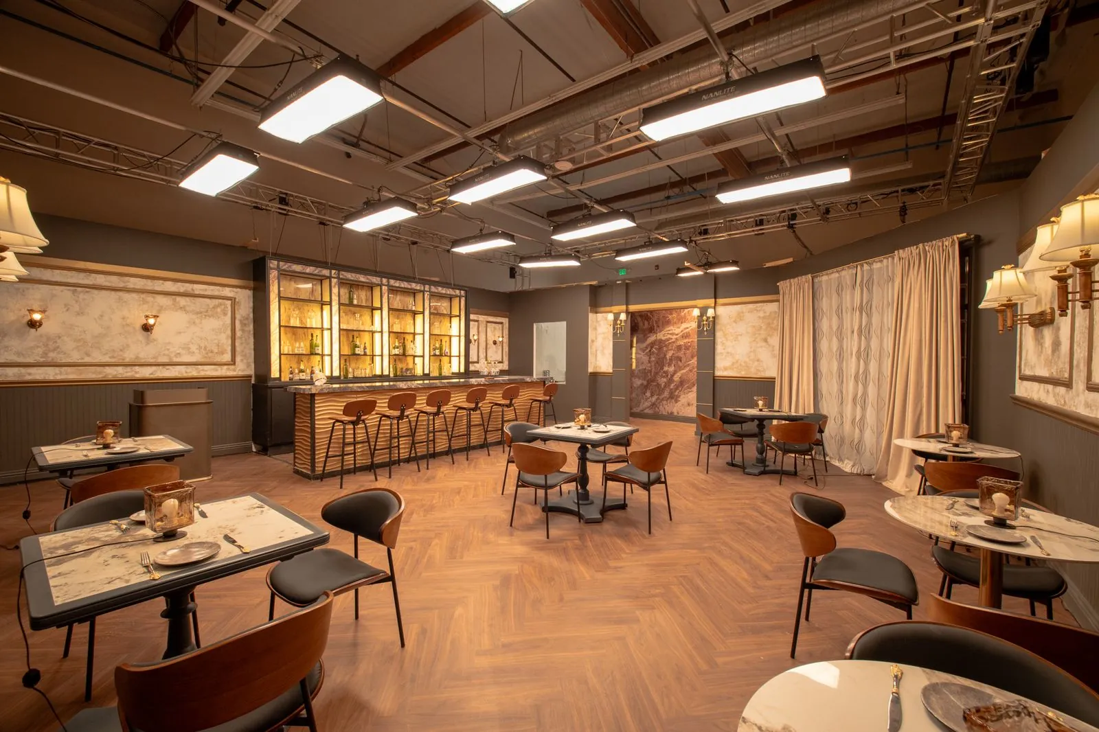 Restaurant tables, sconces and draped window in the dining room