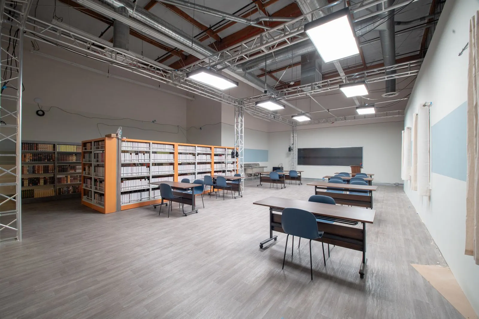 Classroom desks, book stacks and window wall